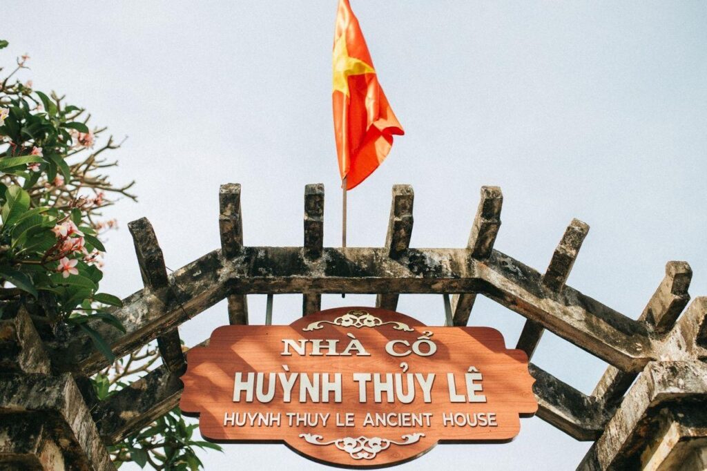 Cận cảnh biển hiệu gỗ ghi danh nhà cổ Huỳnh Thuỷ Lê đặt trang trọng trên cổng vòm rêu phong, điểm check-in mang tính biểu tượng thu hút khách du lịch Sa Đéc.